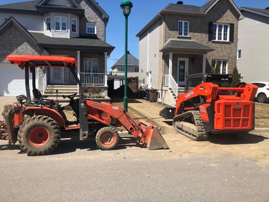 Machinerie de SEI Drain et Paysagement devant une propriété résidentielle