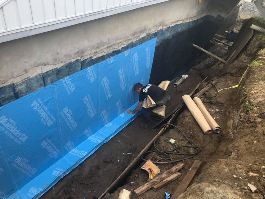 Pose d'une membrane d'imperméabilisation sur une fondation résidentielle